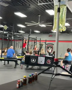 An IV stand and supplements set up beside the floor at a CrossFit competition